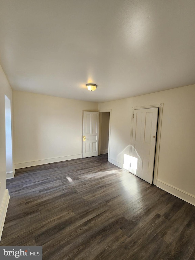 unfurnished room with dark hardwood / wood-style flooring