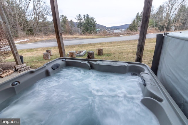 exterior space with a jacuzzi and a mountain view