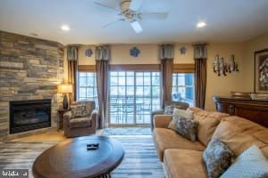 living room with a fireplace and ceiling fan