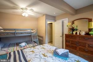 bedroom featuring ceiling fan and beamed ceiling