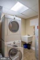 washroom featuring stacked washer and clothes dryer and sink