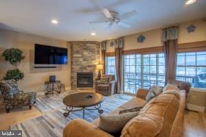 living room featuring hardwood / wood-style floors, a fireplace, and ceiling fan