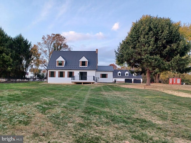 rear view of house featuring a storage shed and a lawn