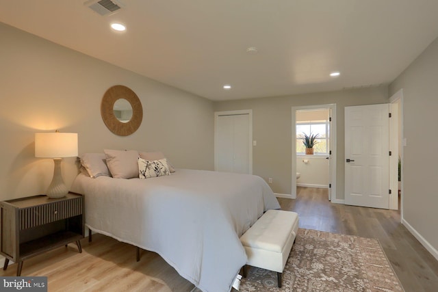 bedroom with light hardwood / wood-style flooring and ensuite bath