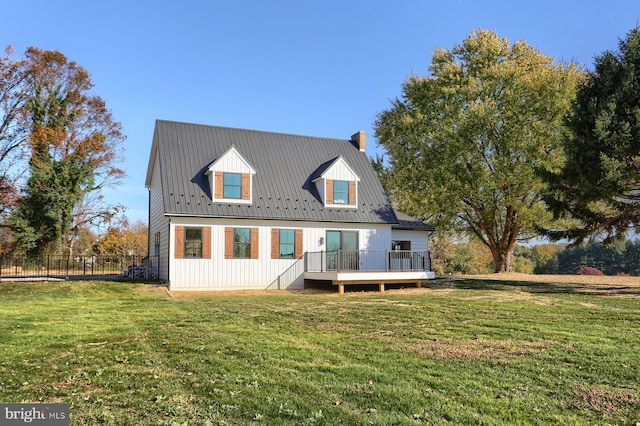 rear view of house featuring a wooden deck and a yard