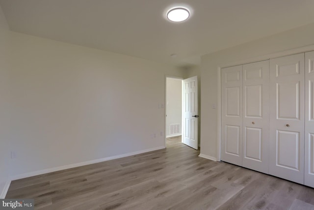 unfurnished bedroom featuring light hardwood / wood-style floors and a closet