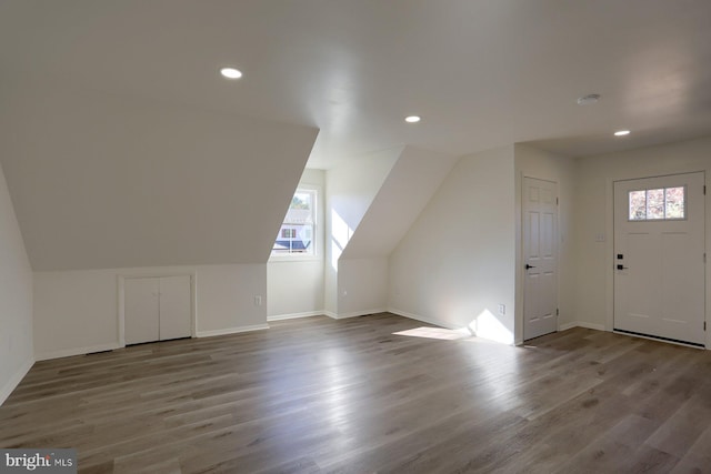 bonus room featuring vaulted ceiling, light hardwood / wood-style floors, and a healthy amount of sunlight