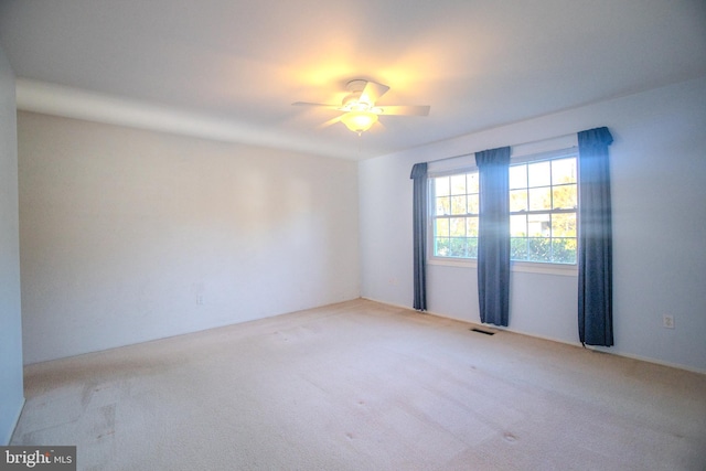 empty room featuring light colored carpet and ceiling fan