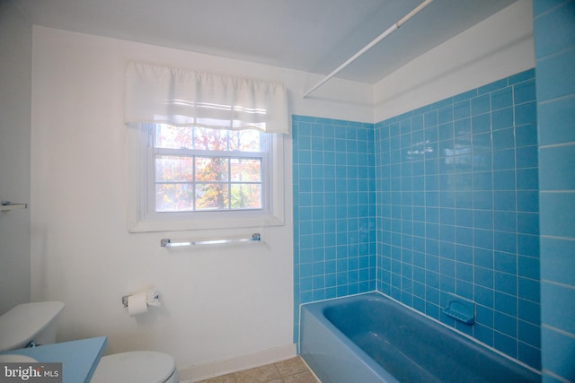 full bathroom with tile patterned flooring, vanity, tiled shower / bath combo, and toilet