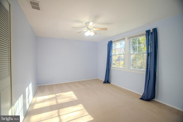 empty room with light colored carpet and ceiling fan