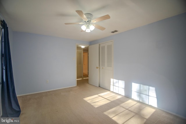 interior space featuring light colored carpet and ceiling fan