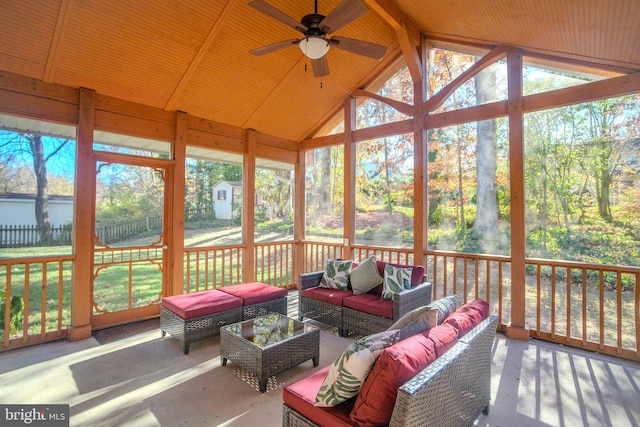 sunroom / solarium featuring ceiling fan, vaulted ceiling with beams, and a healthy amount of sunlight