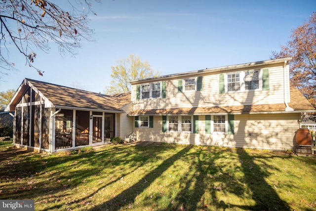 rear view of house with a lawn and a sunroom