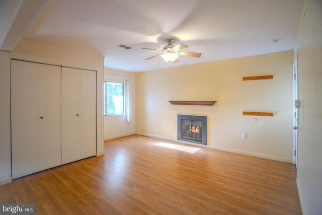 unfurnished living room featuring ceiling fan and light wood-type flooring