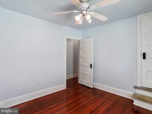 unfurnished room with ceiling fan and dark hardwood / wood-style flooring