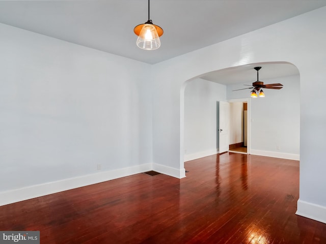 empty room featuring dark wood-type flooring and ceiling fan