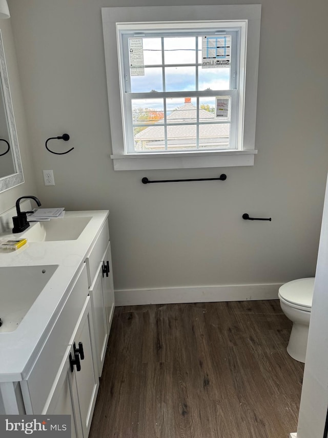 bathroom with hardwood / wood-style floors, vanity, and toilet