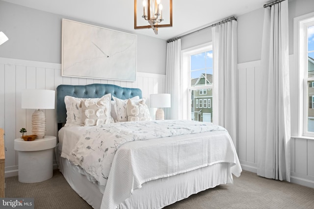 carpeted bedroom featuring a chandelier