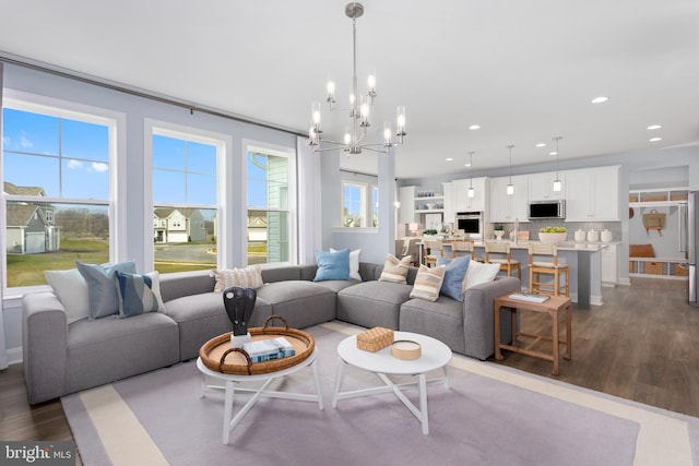 living room featuring a notable chandelier, hardwood / wood-style flooring, and plenty of natural light