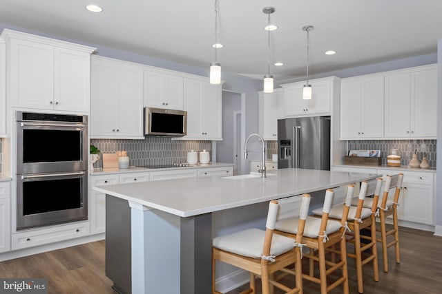 kitchen featuring appliances with stainless steel finishes, a kitchen island with sink, and sink