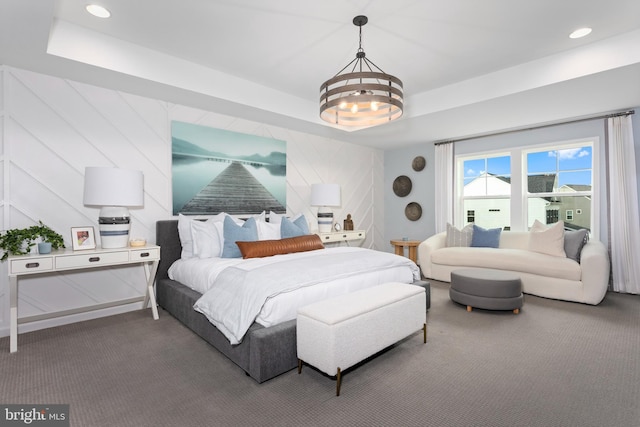 bedroom featuring an inviting chandelier, carpet floors, and a raised ceiling