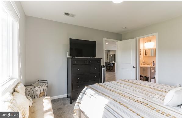 carpeted bedroom featuring connected bathroom