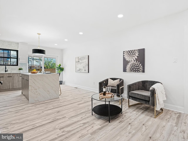 living room with sink and light hardwood / wood-style flooring