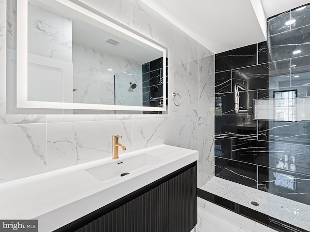 bathroom with vanity, backsplash, tile walls, and tiled shower