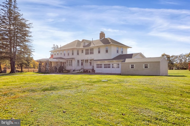 back of property featuring a garage and a lawn