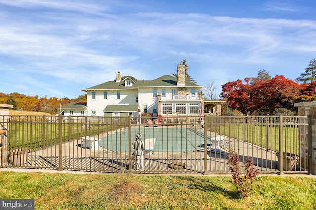 exterior space featuring fence, a chimney, a patio, and a fenced in pool