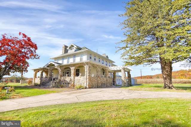 view of front of property featuring covered porch and a front yard