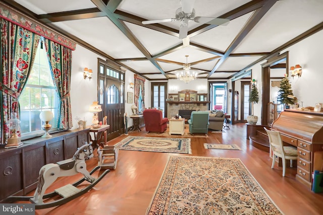 living room with a wealth of natural light, coffered ceiling, hardwood / wood-style floors, and a stone fireplace