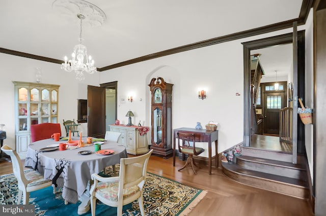 dining room with an inviting chandelier, ornamental molding, and wood-type flooring