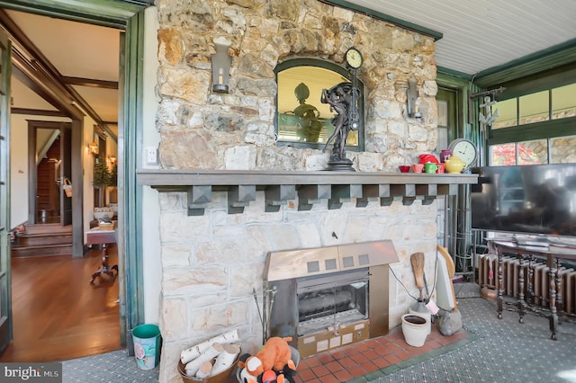 interior space with crown molding and a stone fireplace