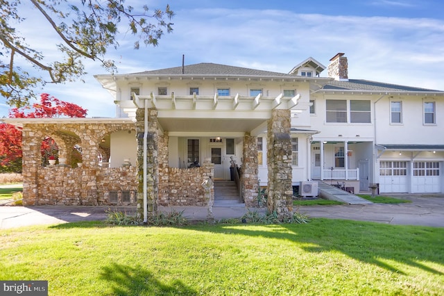 view of front facade featuring a front yard, ac unit, a garage, and a porch