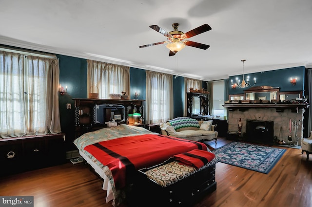 bedroom with ceiling fan with notable chandelier, wood-type flooring, ornamental molding, and a fireplace