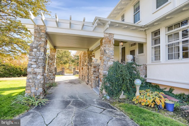 exterior space featuring stucco siding and stone siding