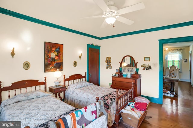 bedroom featuring baseboards, wood finished floors, and ceiling fan