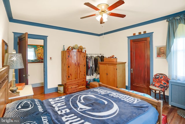 bedroom featuring crown molding, ceiling fan, baseboards, radiator heating unit, and wood finished floors