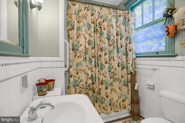 bathroom with toilet, a shower with curtain, and tile walls