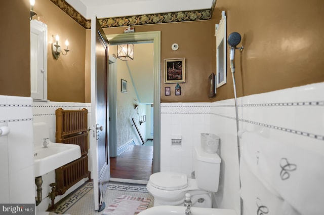 bathroom with tile walls, wood-type flooring, a bidet, and toilet