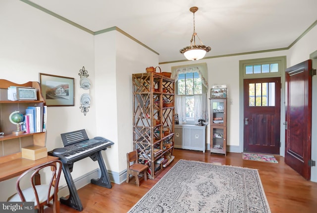 entrance foyer featuring baseboards, wood finished floors, and crown molding