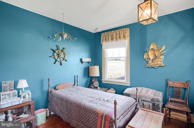 bedroom featuring an inviting chandelier, hardwood / wood-style floors, and crown molding