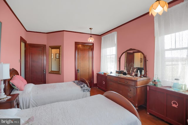 bedroom featuring wood finished floors and ornamental molding