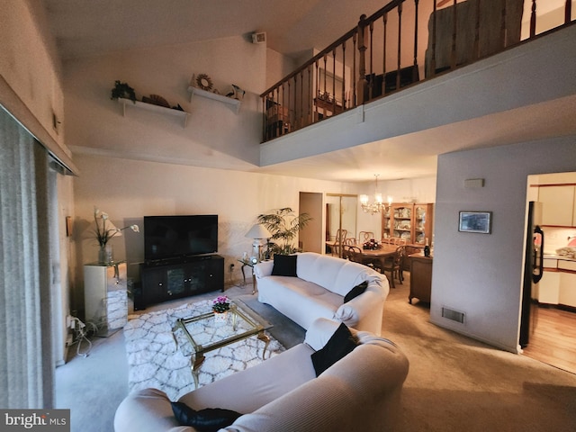 living room featuring a notable chandelier, light hardwood / wood-style floors, and a towering ceiling