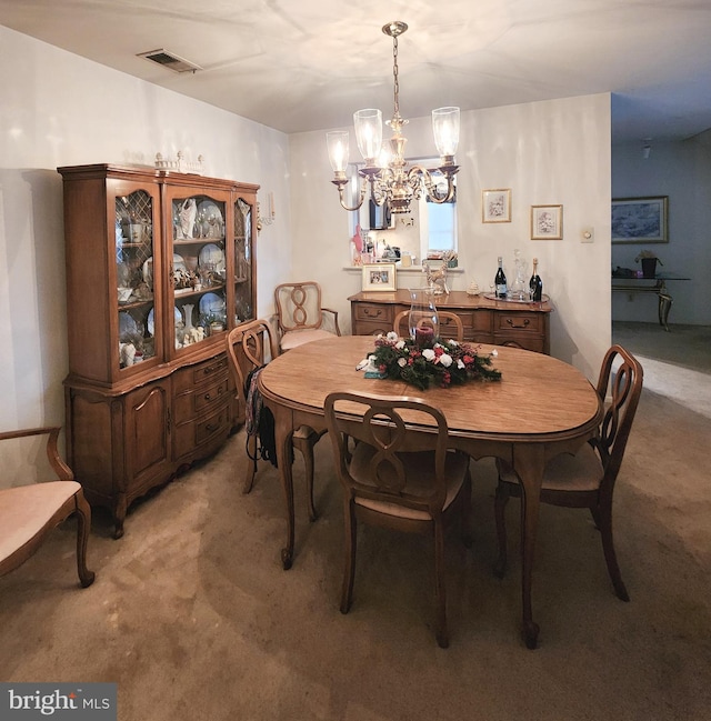 carpeted dining room featuring an inviting chandelier