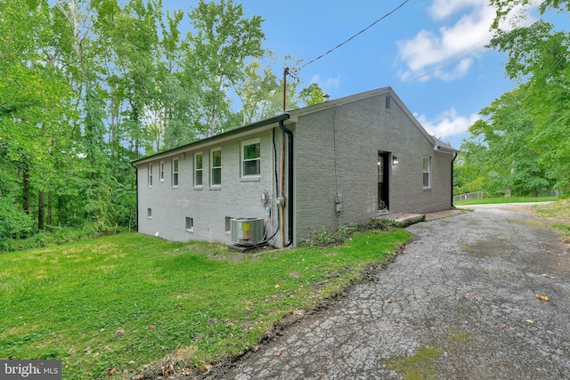 view of home's exterior featuring a yard and central AC unit