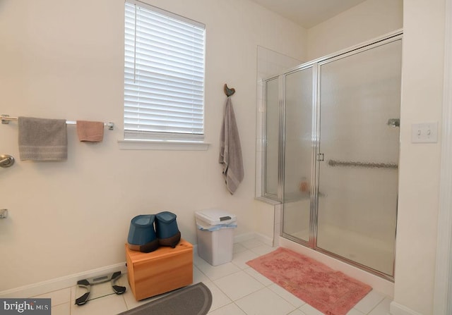 bathroom with tile patterned floors, plenty of natural light, and a shower with shower door