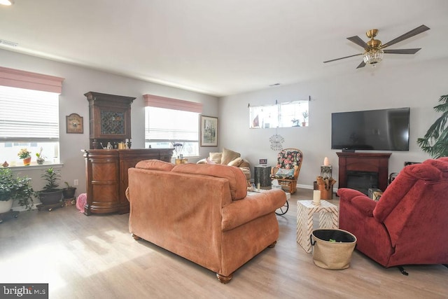 living room featuring ceiling fan, light hardwood / wood-style floors, and a wealth of natural light