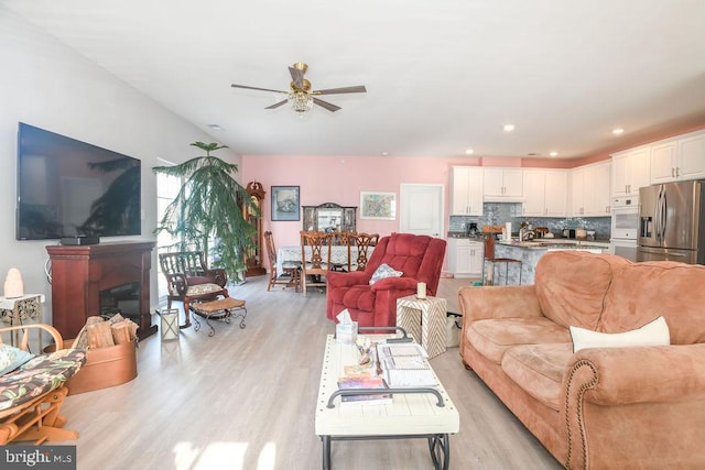 living room featuring ceiling fan and light hardwood / wood-style flooring